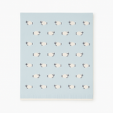Patterned blanket with sheep design on a light blue background