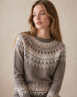 Woman wearing a patterned sweater against a beige background
