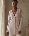 Woman wearing a light beige cashmerewool long cardigan in a neutral setting