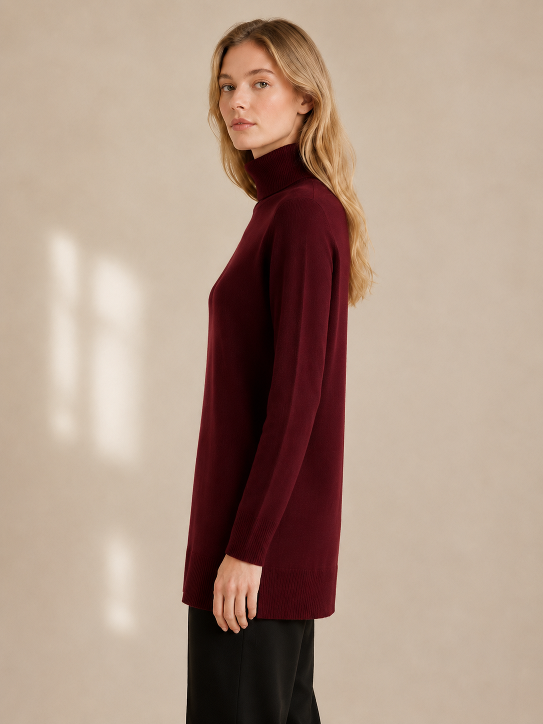 Woman wearing a burgundy turtleneck sweater against a beige background