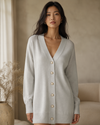 Woman wearing a light gray cashmere cardigan with a neutral background